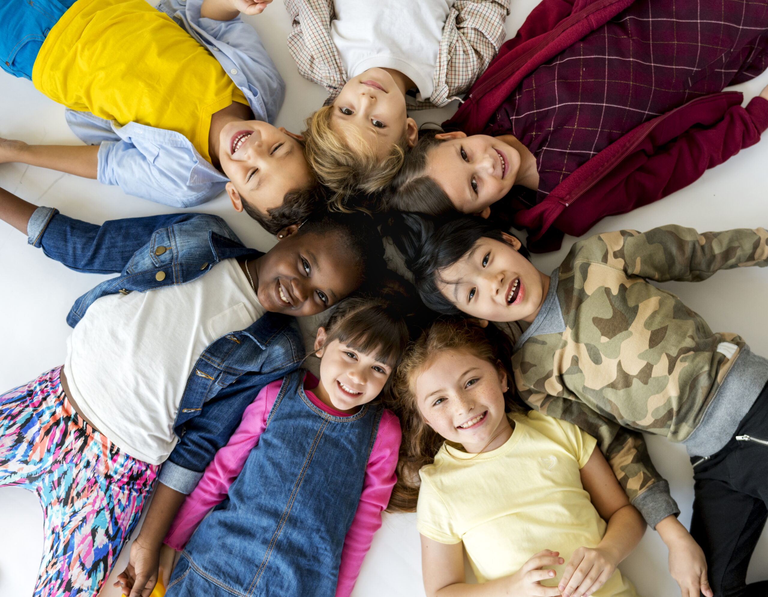 A group of primary schoolers lying on the ground and smiling